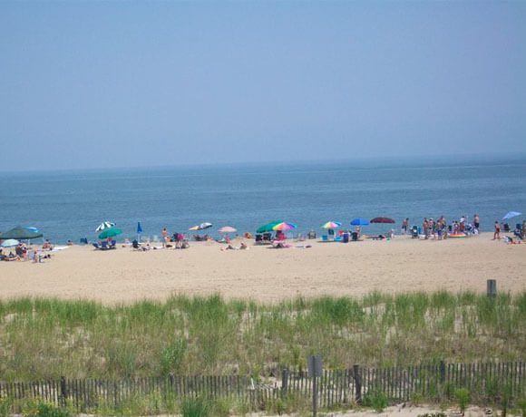 A wide shot of Dewey beach with people on it.